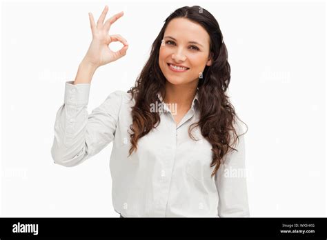 Portrait Of A Brunette Approving With Hand Against White Background