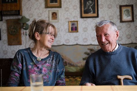 Senior Man And Younger Woman Talking In The Living Room By Stocksy