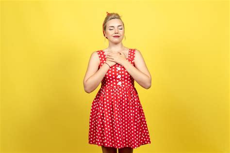 Mujer Joven En Vestido Rojo De Lunares Posando En Amarillo Foto Gratis