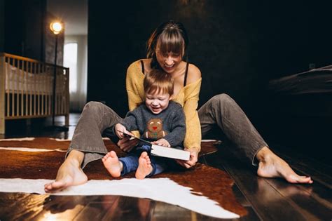 Mère Avec Son Fils Jouant Un Livre De Lecture Photo Gratuite