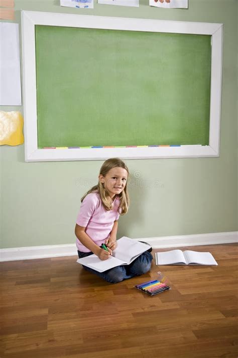 Child Sitting On Floor Writing In Classroom Royalty Free Stock Photo - Image: 15847015