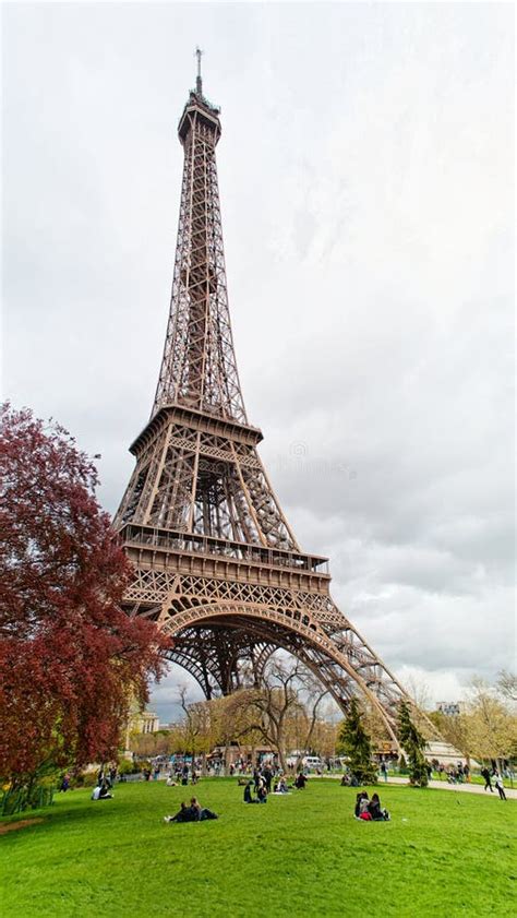 Eiffel Tower With People Sitting On Grass In Paris Editorial Photo