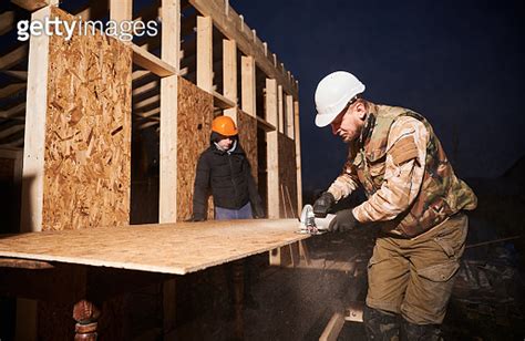 Carpenter Using Circular Saw For Cutting Osb Board For Building Wooden