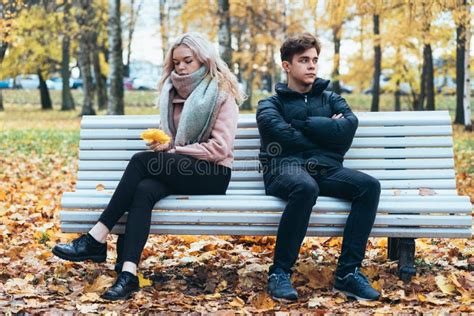 Twee Tieners Uit Liefde In Ruzie Brunette Boy En Blond Meisje Zitten Aan De Andere Kant Van