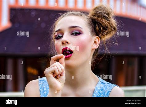 Une Femme Tient Une Cerise Dans Sa Bouche Sur La Toile De Fond Dun