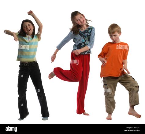 Three young children are dancing and laughing together and are ...