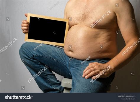 Overweight Shirtless Caucasian Man Sitting Down Stock Photo