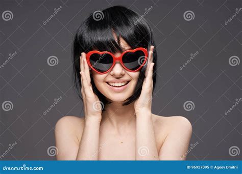 Jeune Belle Femme Sur Un Fond Noir Dans Des Lunettes De Soleil Au Coeur