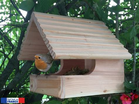 A Bird Is Sitting On Top Of A Wooden Bird House