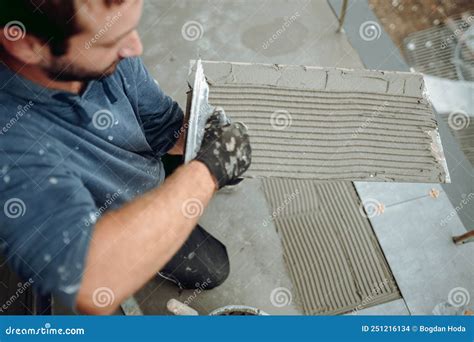 Worker Placing Ceramic Floor Tile In Position Over Adhesive Stock Photo