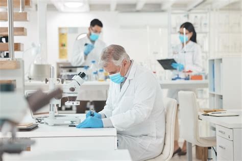 Plan D un Scientifique Mature écrivant Des Notes Tout En Travaillant Dans Un Laboratoire Photo