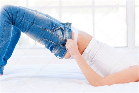 Woman Pulling On Tight Jeans — Stock Photo © Gstockstudio 45400535