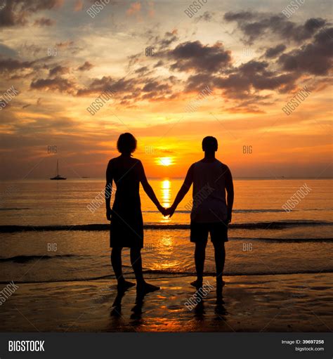 Pareja joven/esposos manos de celebración en la playa de la mar al atardecer Fotos stock e ...