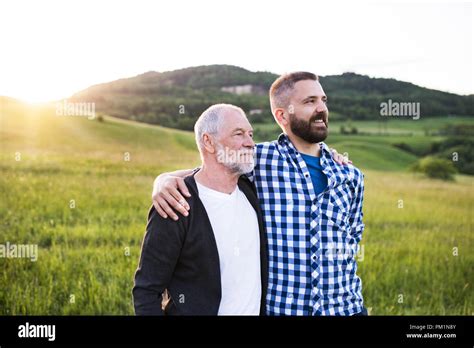 A Portrait Of An Adult Hipster Son With Senior Father In Nature At