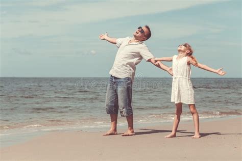 Pai E Filha Que Jogam Na Praia No Tempo Do Dia Imagem De Stock Imagem