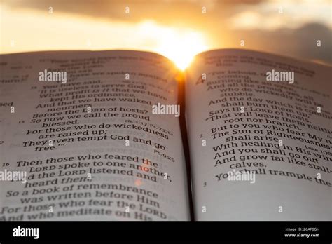 Holy Bible Open At Sunset With Highlight On Malachi 42 Background With Clouds And Sun Stock