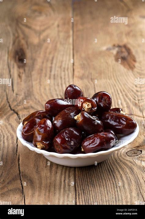 Dates on wooden background. Dried dates fruit Stock Photo - Alamy