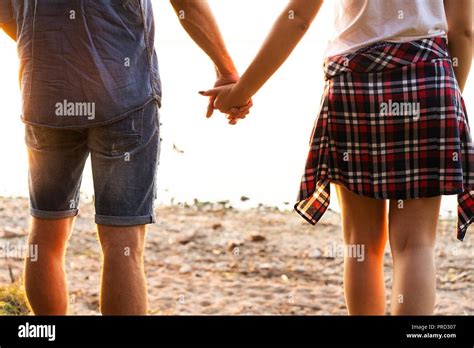 Young Couple In Love Walking In The Autumn Park Holding Hands Looking