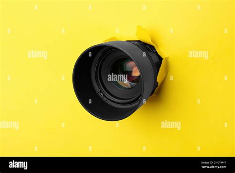 Hidden Camera Lens Through Hole In Yellow Paper Stock Photo Alamy