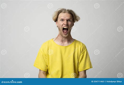 Angry Sad Aggressive Young Man In A Yellow T Shirt Screaming On A