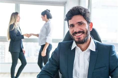 Retrato Del Hombre De Negocios Sonriente Delante De Las Mujeres Que