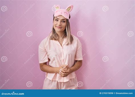 Blonde Caucasian Woman Wearing Sleep Mask And Pajama With Hands