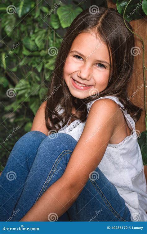 Portrait D Une Petite Fille S Asseyant Dans Le Jardin Fleuri Photo