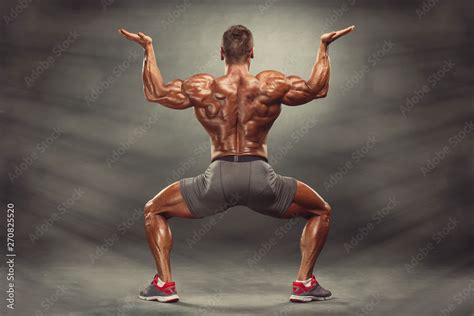 Strong Muscular Men Flexing Muscles from the Back. He is showing back ...