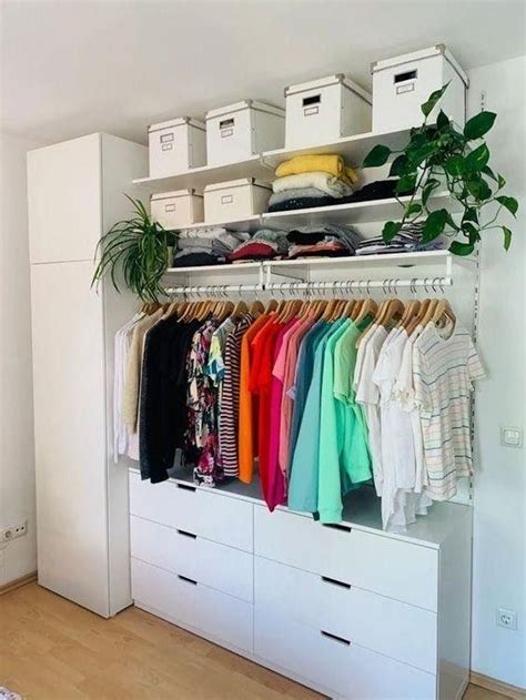 An Organized Closet With White Drawers And Clothes Hanging On The Rails