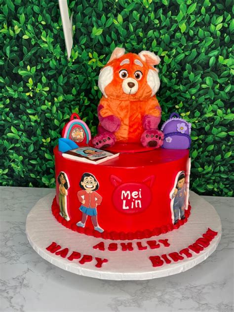 A Birthday Cake With An Orange Teddy Bear And Other Toys On It S Top