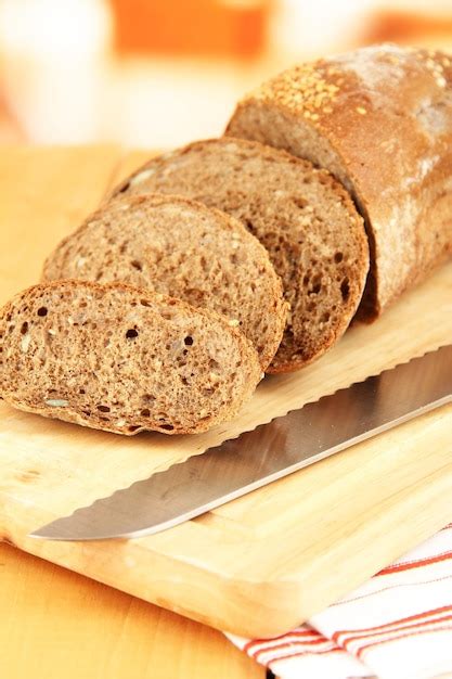 Pan rebanado con semillas de sésamo y cuchillo en una tabla de cortar