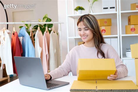 Small Business Owner Checking Product Stock By Laptop Computer At Home