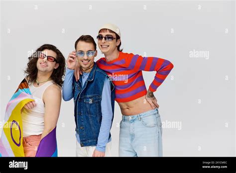Cheerful Appealing Gay Men With Trendy Sunglasses Holding Rainbow Flag
