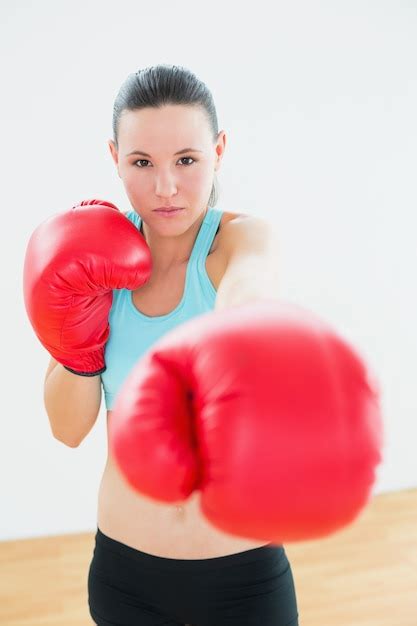 Hermosa Mujer En Guantes De Boxeo Rojos En El Gimnasio Foto Premium