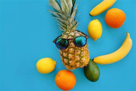 Premium Photo Pineapple In Stylish Sunglasses And Bananas Oranges Avocado And Lemons On Bright