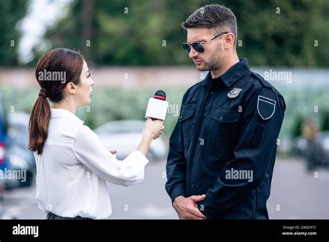 journalist holding microphone and talking with handsome policeman in ...