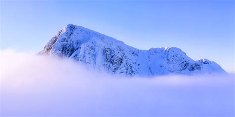 Landscape Photography Of Snowy Mountain Summit Above Clouds Under Clear