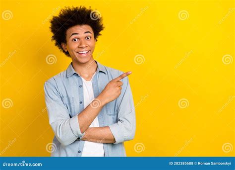 Photo Of Cheerful Excited Man Wear Jeans Shirt Pointing Finger Empty Space Isolated Yellow Color