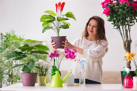 Premium Photo | Young woman looking after plants at home