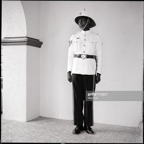 A Jamaican Police Officer Stands Guard Wearing An Official Uniform