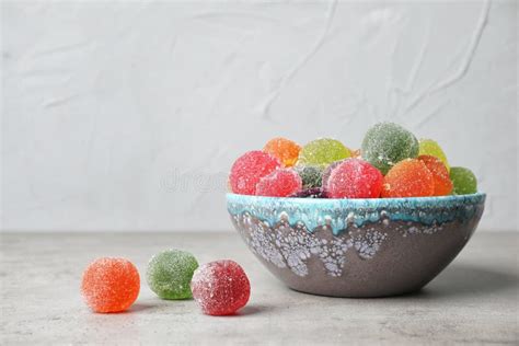 Шар с очень вкусными красочными конфетами на таблице против серой ...