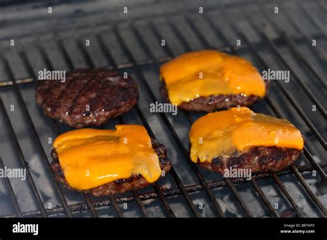 Hamburger patties with cheese cooking on a grill Stock Photo - Alamy