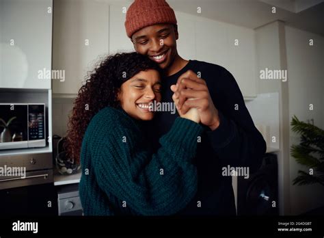 Young Happy Mixed Race Couple Holding Hands In The Kitchen Mixed Race