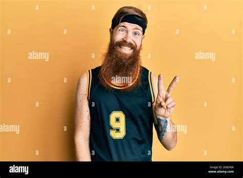 Redhead Man With Long Beard Wearing Basketball Uniform Smiling With