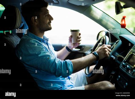 Transportation And Vehicle Concept Man Drinking Coffee While Driving