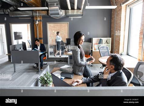 Business People Talking At Desk In Open Plan Office Stock Photo Alamy