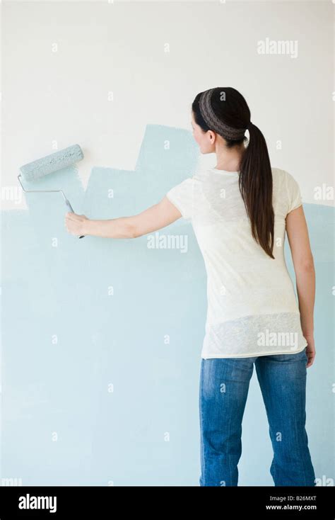 Woman Painting Wall With Paint Roller Stock Photo Alamy