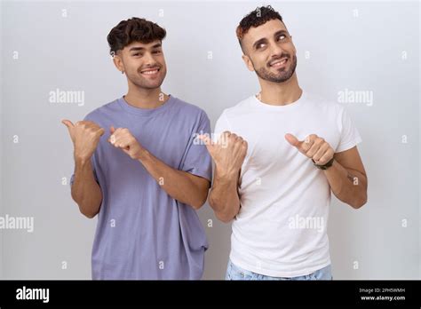 Homosexual Gay Couple Standing Over White Background Pointing To The