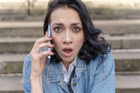 Outdoor Portrait Of An Upset Young Woman In A Denim Jacket Is Talking