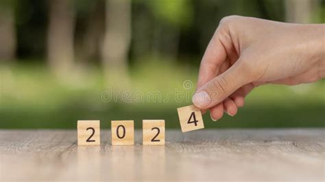 2024 Block Over 2023 And 2022 Wooden Building On Table Background